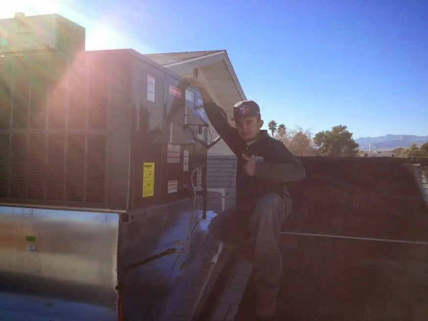 HVAC technician performing AC Tune-Up on a rooftop unit in Miami Shores